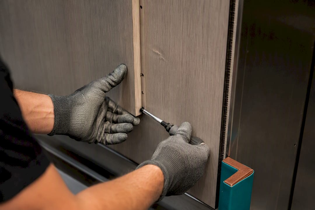 Technician replacing one elevator wall panel
