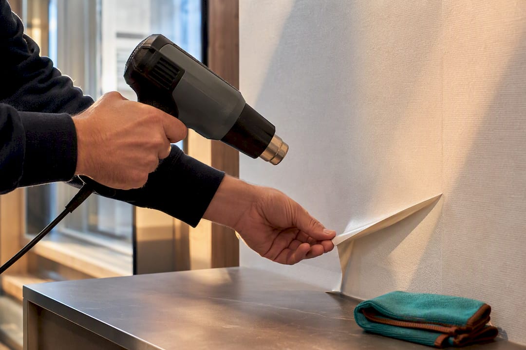 Heat gun warming film during controlled removal