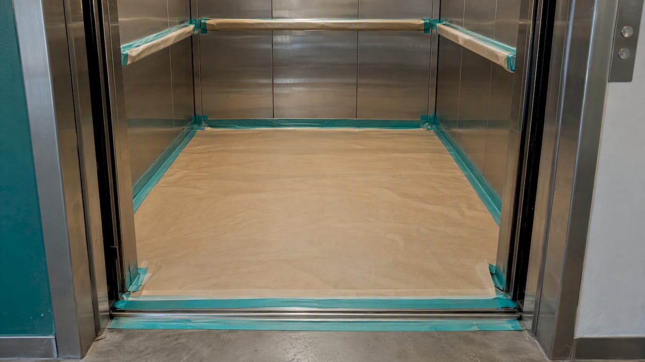Elevator cab floor and sill protected before wrapping