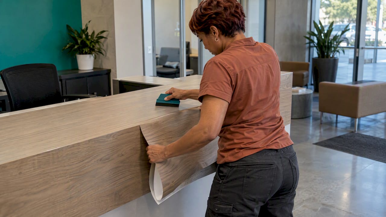 Installer applying film to a reception counter